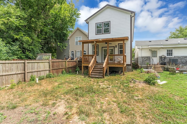 back of house featuring ceiling fan and a lawn