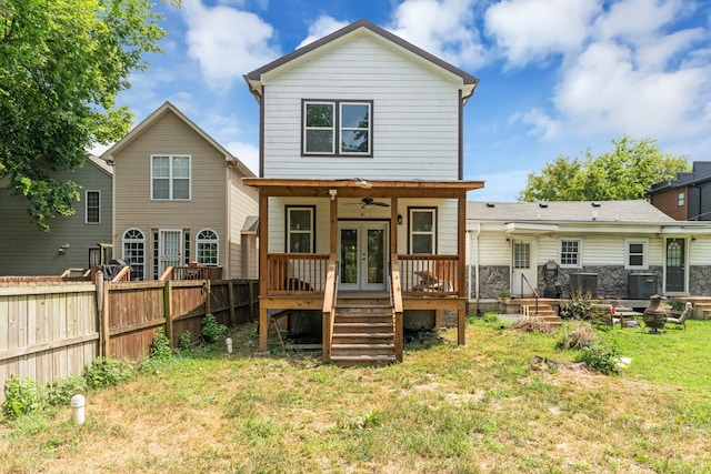 rear view of property featuring a yard, ceiling fan, and cooling unit