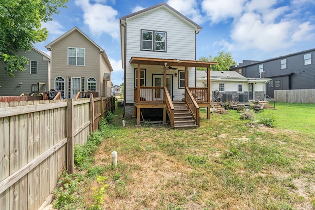 back of property featuring a lawn and ceiling fan