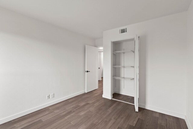 unfurnished bedroom with dark hardwood / wood-style flooring