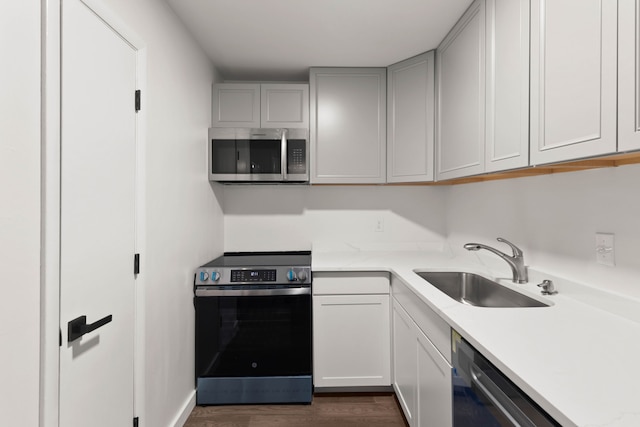 kitchen with sink, appliances with stainless steel finishes, and dark wood-type flooring