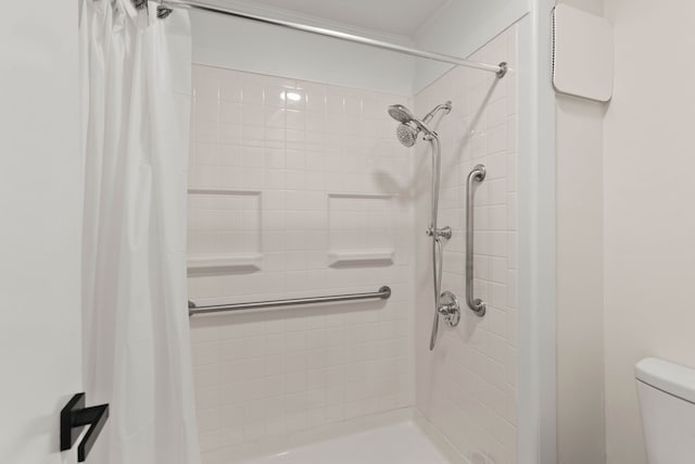 bathroom with a shower with shower curtain and toilet