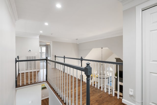 hallway featuring ornamental molding, dark wood-type flooring, and an inviting chandelier