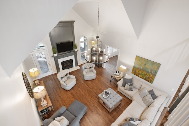 living room featuring hardwood / wood-style flooring, high vaulted ceiling, and a notable chandelier