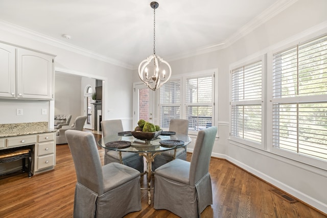 dining area featuring dark wood-type flooring, a chandelier, and crown molding