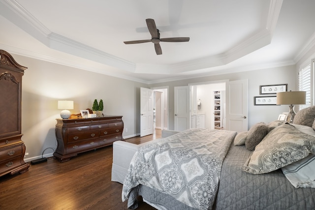 bedroom with ceiling fan, dark hardwood / wood-style floors, a raised ceiling, and a walk in closet