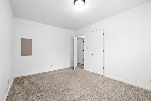 unfurnished bedroom featuring carpet, electric panel, and a textured ceiling