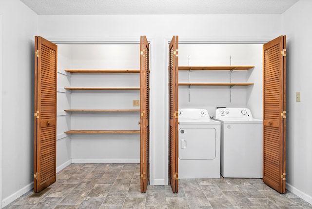 laundry room featuring washer and clothes dryer and a textured ceiling