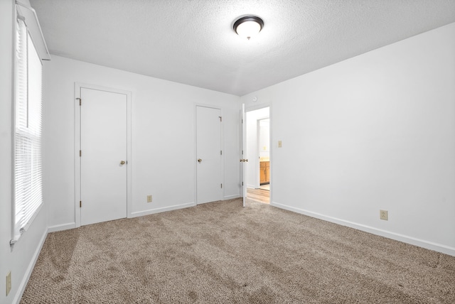 unfurnished bedroom featuring a textured ceiling and carpet flooring