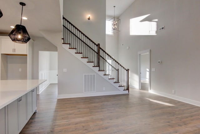 interior space with a notable chandelier, hardwood / wood-style floors, and a high ceiling