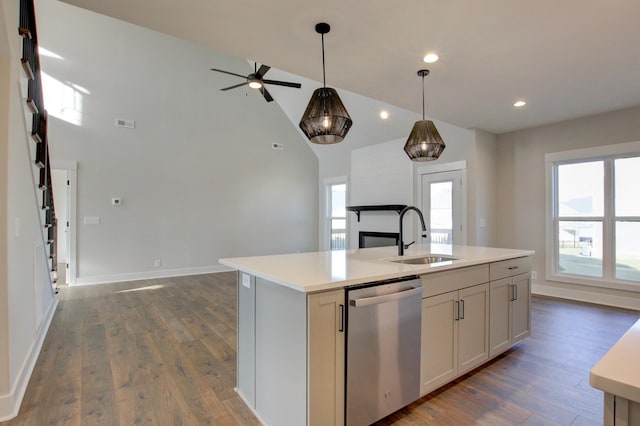 kitchen with sink, stainless steel dishwasher, a healthy amount of sunlight, and a center island with sink