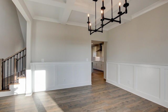 unfurnished dining area with crown molding, an inviting chandelier, hardwood / wood-style floors, coffered ceiling, and beamed ceiling