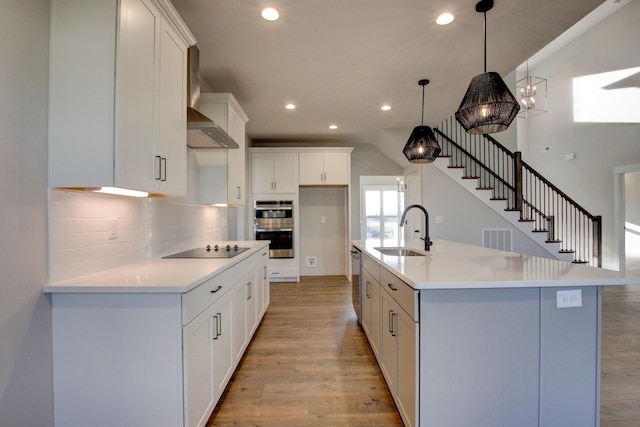 kitchen featuring pendant lighting, a large island, white cabinetry, and appliances with stainless steel finishes