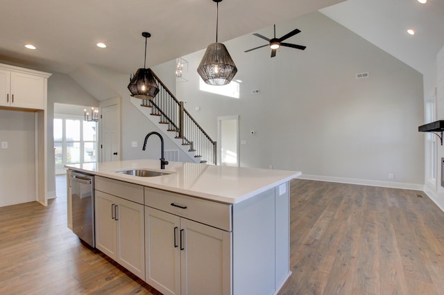 kitchen with sink, a kitchen island with sink, white cabinetry, high vaulted ceiling, and stainless steel dishwasher