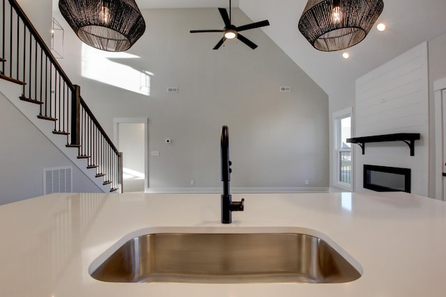 kitchen with ceiling fan, sink, and high vaulted ceiling