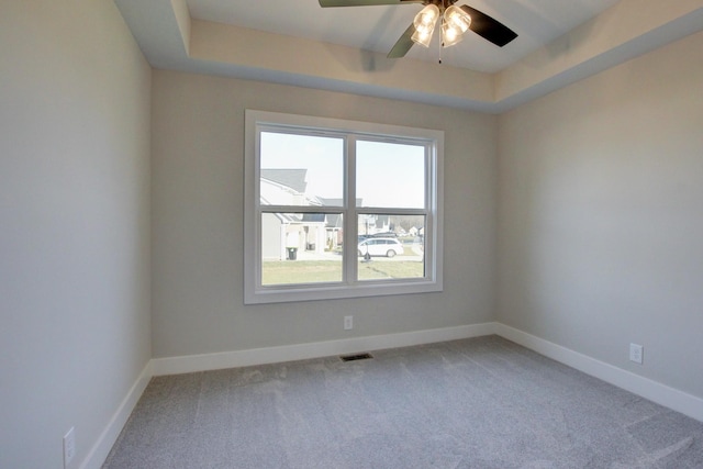 unfurnished room with carpet flooring, ceiling fan, and a tray ceiling