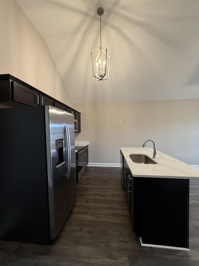 kitchen with stainless steel refrigerator with ice dispenser, lofted ceiling, sink, light stone counters, and decorative light fixtures