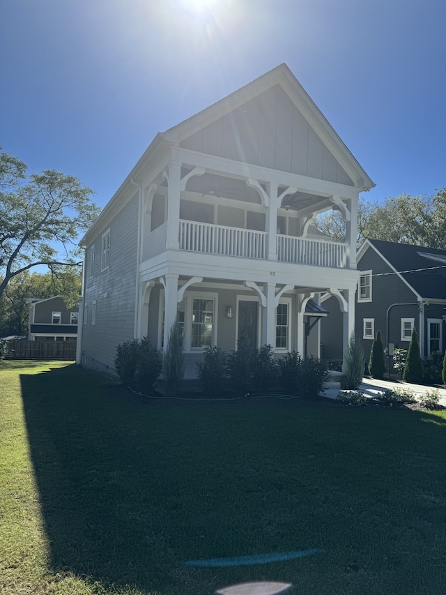 view of front of property featuring a front yard and a balcony