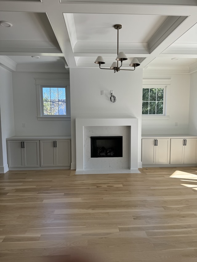 unfurnished living room featuring light wood-type flooring, plenty of natural light, and beamed ceiling