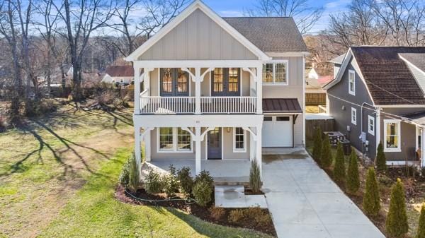 view of front of home with driveway, board and batten siding, and a front yard