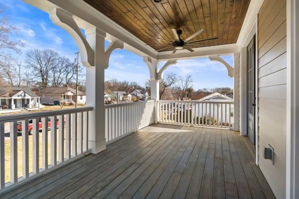 wooden deck with a ceiling fan and a residential view