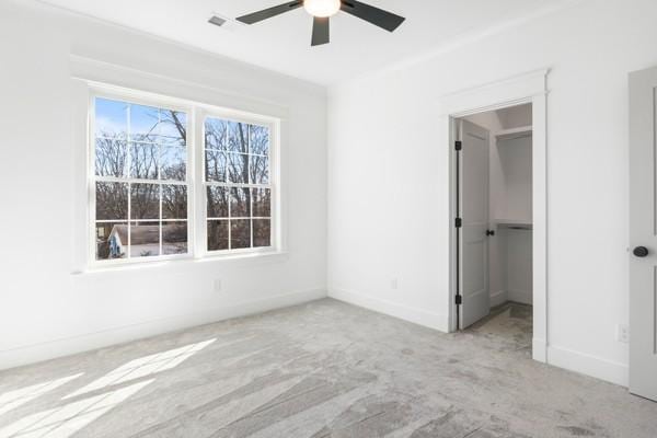 unfurnished bedroom featuring carpet, a ceiling fan, and baseboards