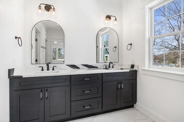 bathroom featuring marble finish floor, plenty of natural light, and a sink