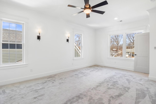 empty room with carpet, visible vents, ceiling fan, and baseboards