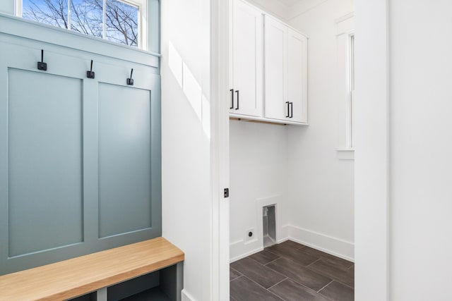 interior space with cabinet space, baseboards, hookup for an electric dryer, and wood finish floors