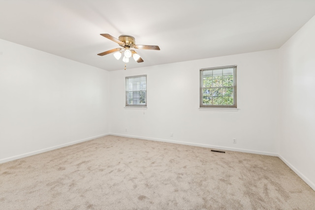 empty room with ceiling fan and carpet floors