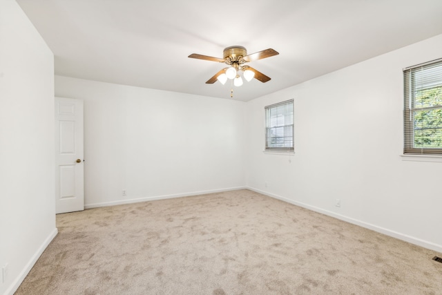 unfurnished room with light colored carpet and ceiling fan