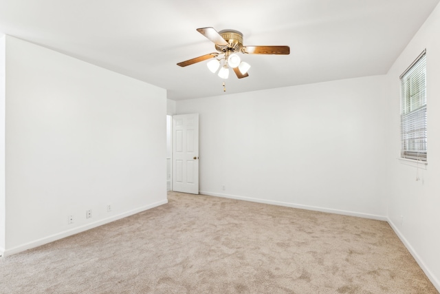 carpeted spare room featuring ceiling fan