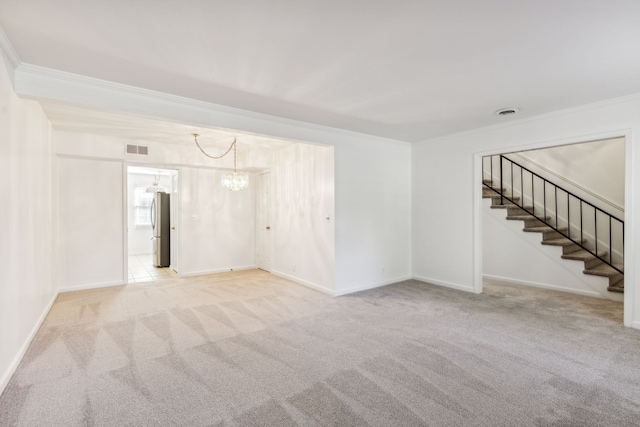 carpeted spare room with a chandelier and crown molding