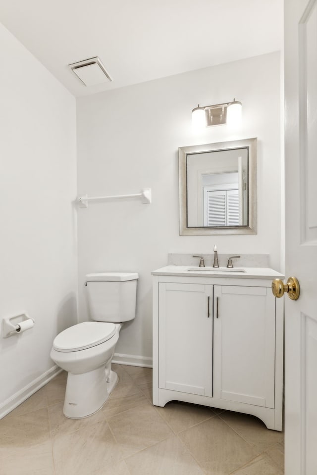 bathroom with tile patterned flooring, vanity, and toilet