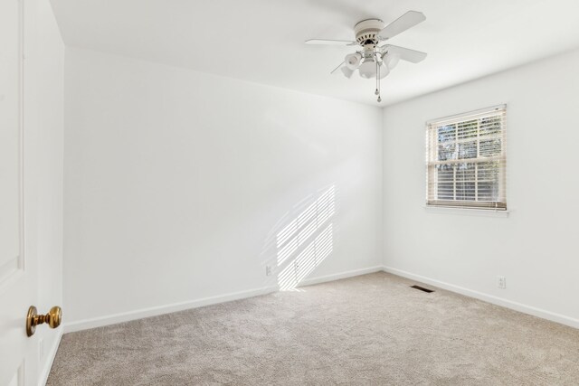 carpeted spare room featuring ceiling fan