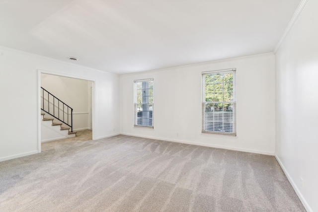 empty room featuring light carpet and crown molding