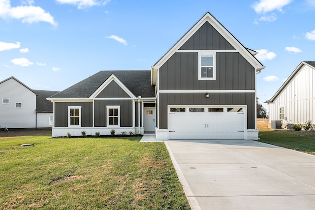 view of front of house with a garage, a front yard, and central AC