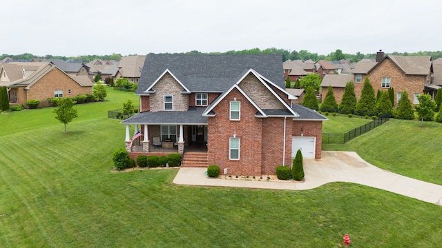 view of front of property with a garage, covered porch, and a front lawn