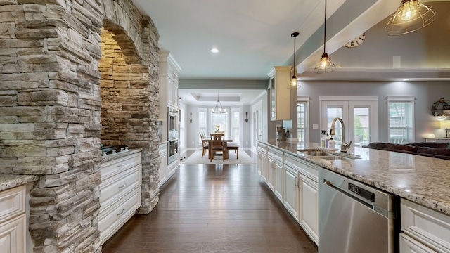 kitchen featuring pendant lighting, sink, white cabinets, light stone counters, and stainless steel appliances