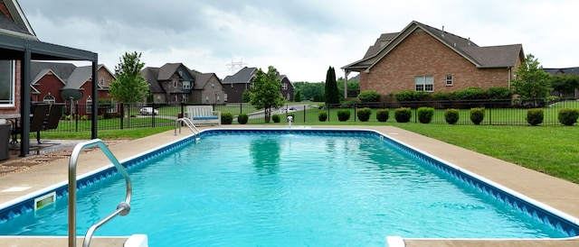 view of pool featuring pool water feature and a lawn