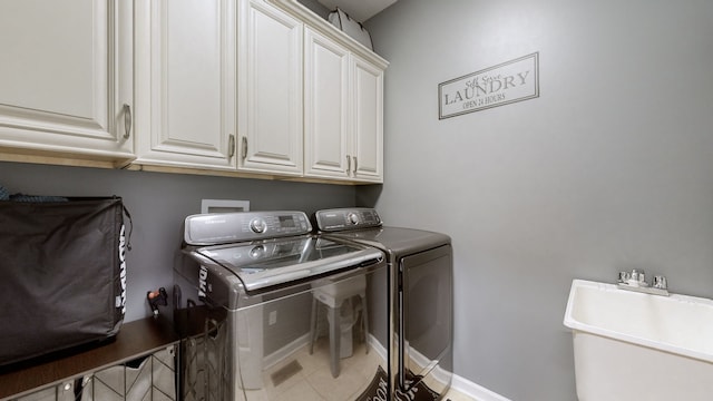 laundry room with cabinets, separate washer and dryer, sink, and tile patterned floors