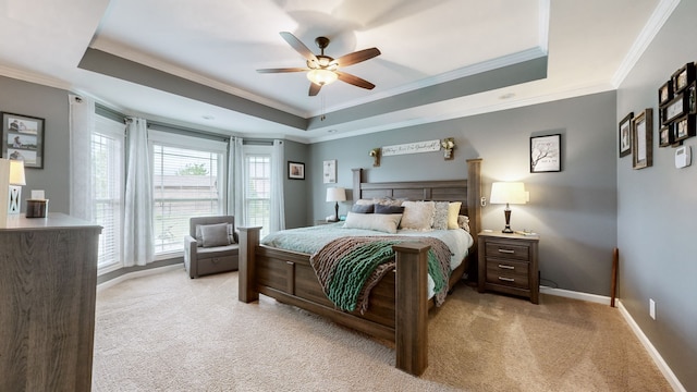 carpeted bedroom featuring a raised ceiling, crown molding, and ceiling fan