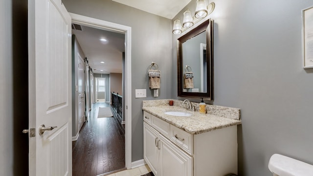 bathroom featuring vanity, toilet, and hardwood / wood-style floors