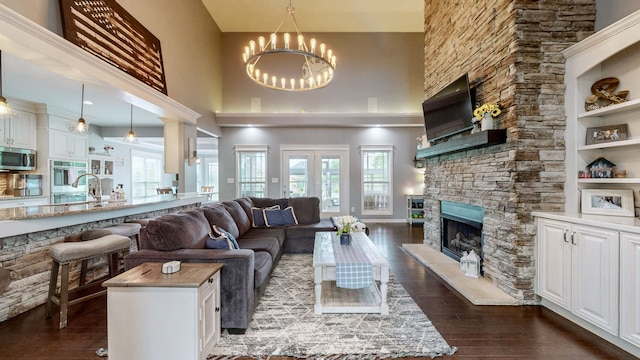 living room featuring a wealth of natural light, a chandelier, and dark hardwood / wood-style flooring