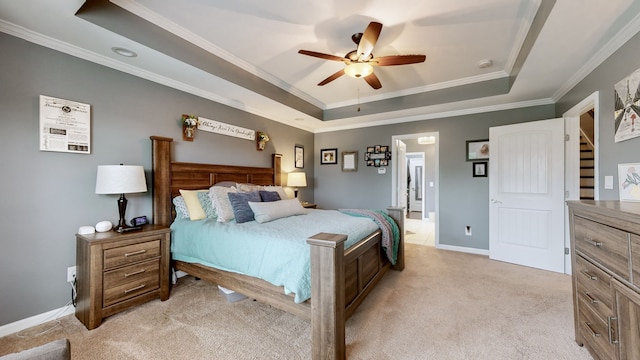 bedroom with a tray ceiling, ornamental molding, light colored carpet, and ceiling fan