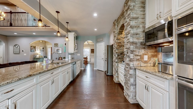 kitchen featuring white cabinetry, sink, stainless steel appliances, and hanging light fixtures