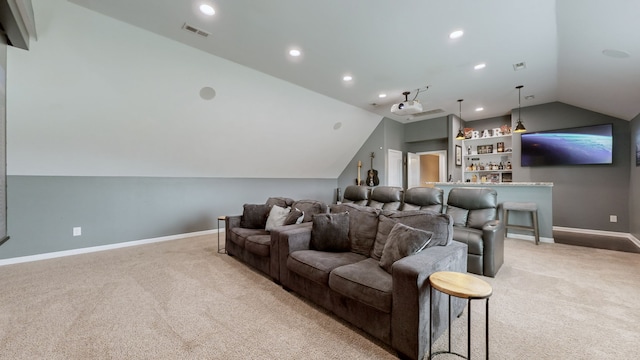 carpeted cinema featuring indoor bar and vaulted ceiling