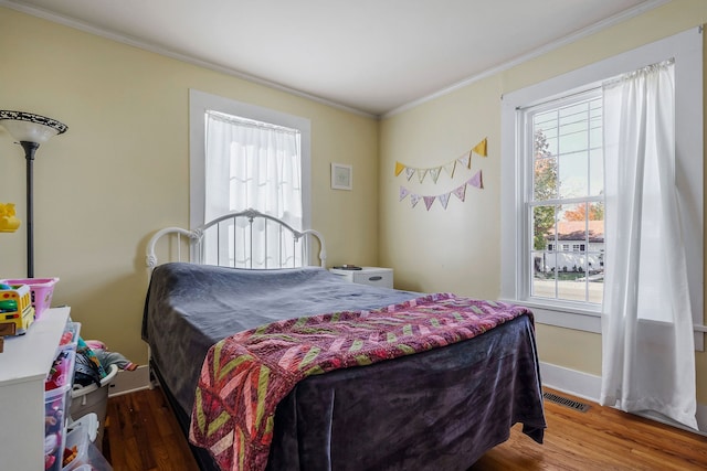 bedroom with dark hardwood / wood-style floors and crown molding