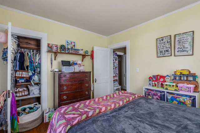 bedroom with a closet, hardwood / wood-style floors, and ornamental molding