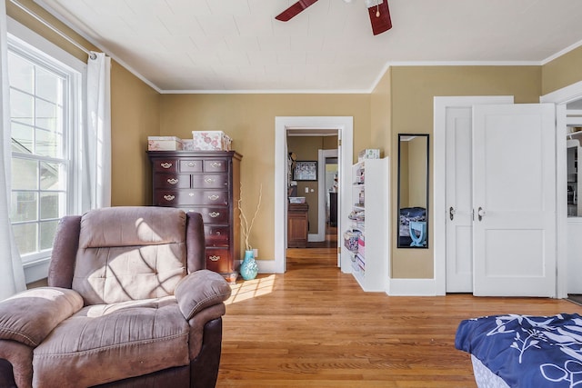 sitting room with a wealth of natural light, ceiling fan, light wood-type flooring, and ornamental molding